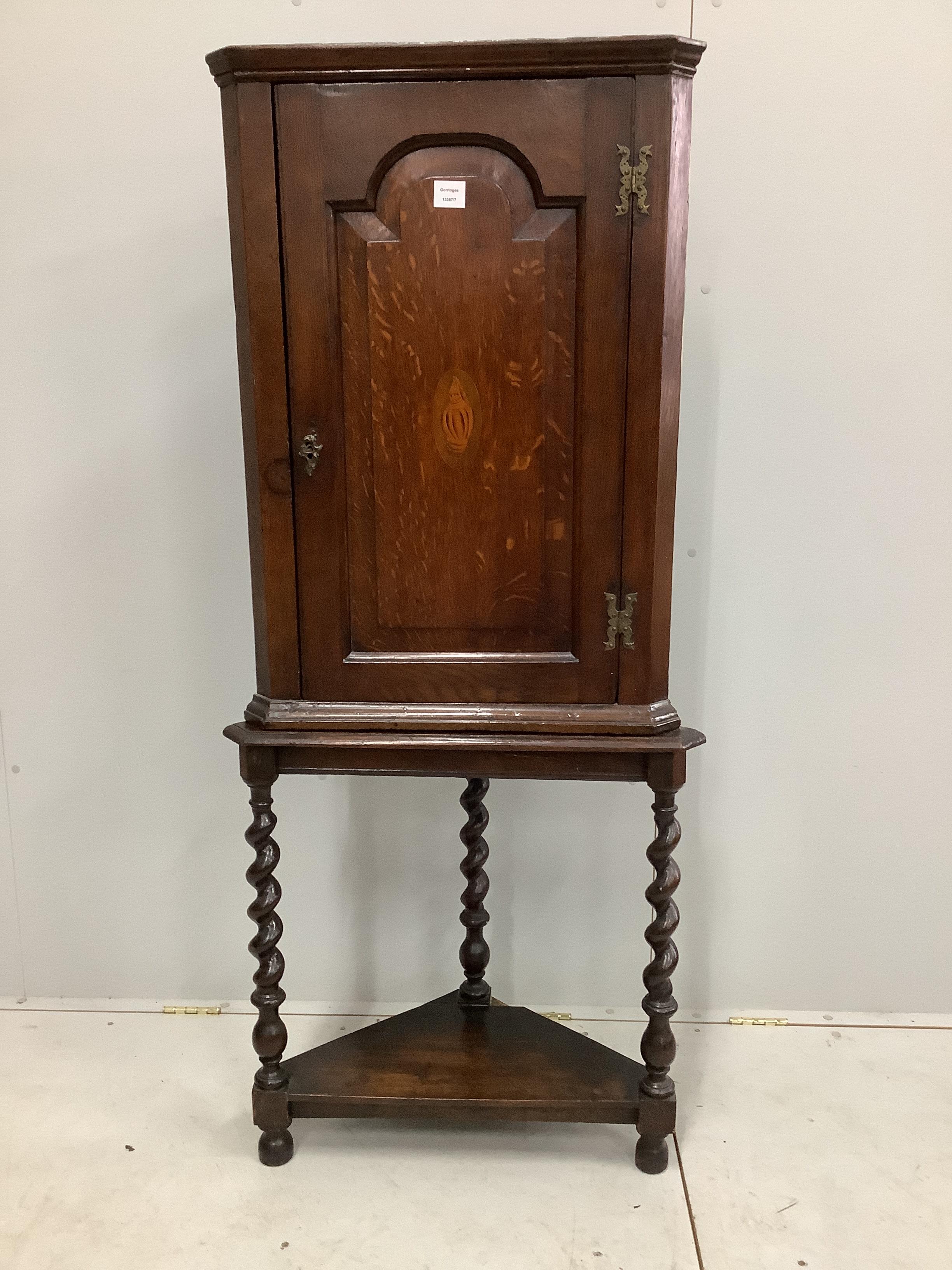 A George III inlaid oak corner cupboard on associated stand, width 62cm, depth 31cm, height 159cm